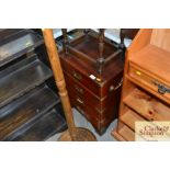 A campaign style bedside chest fitted three drawer