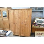 A pair of stripped pine hanging wardrobes