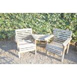 A pair of teak armchairs with integral table