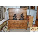 A reproduction oak dresser with fitted shelf and b