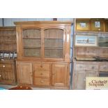 An antique stripped pine kitchen dresser with glazed top