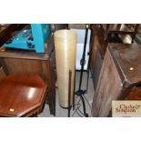 A retro teak standard lamp with plastic tubular sh