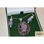 A boxed amethyst coloured and white metal pendant