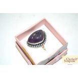 A white metal dress ring with amethyst coloured st