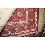 An approx. 6'8" x 4'9" red Eastern pattern rug