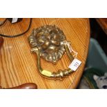 A brass lion mask door knocker