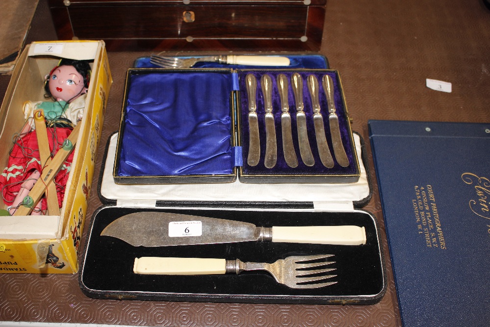 A pair of cased plated fish servers, a plated cake
