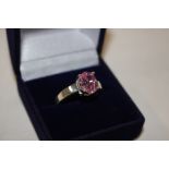 A boxed pink stone and white metal dress ring