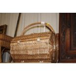 A wicker picnic hamper and two other wicker basket