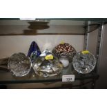 A collection of various glass paperweights