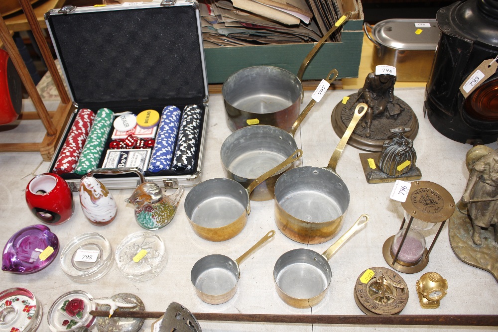 A set of graduated brass and copper saucepans