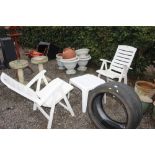 A pair of plastic garden chairs and side table