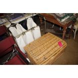 A wicker storage basket and contents of blankets,