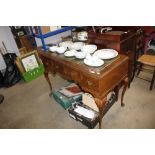 A walnut veneered writing table with green leather