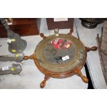 A ship's porthole mirror mounted to a ship's wheel