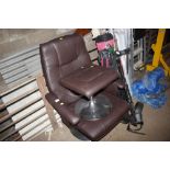 A faux leather upholstered armchair and foot stool