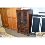 A Spanish style wooden and metal fronted unit with