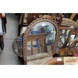 An arched framed mirror and a bevel edged oval mir