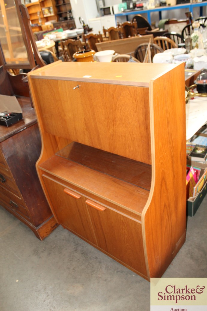 A teak drinks cabinet with full front raised on cu