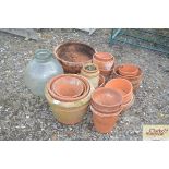 A grass carboy and a quantity of terracotta pots