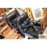 A pair of leather swing chairs with matching foot