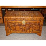 An Oriental carved camphor wood trunk, decorated f