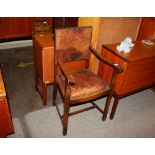 A 1930's oak office elbow chair with leather uphol