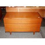 A teak low chest fitted three drawers and raised o