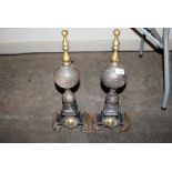 A pair of cast iron and brass fire dogs of baluste