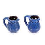 A pair of Branham blue glazed pottery puzzle jugs