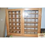 A pine hanging cabinet with pigeon hole interior