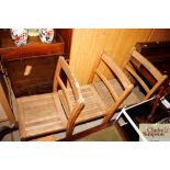 Three wooden school chairs with metal brackets