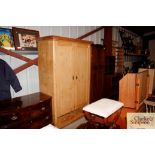 A stripped pine hanging wardrobe with drawer to ba