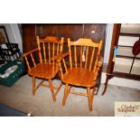 A pair of pine kitchen elbow chairs