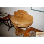 An antique stripped pine demi-lune side table