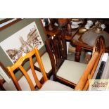 A set of four slat backed dinning chairs