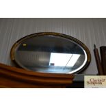 An oval and bevel edged wall mirror