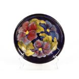 A Moorcroft "Hibiscus" pattern plate, impress mark and W.M. signature to the reverse, 21cm dia.
