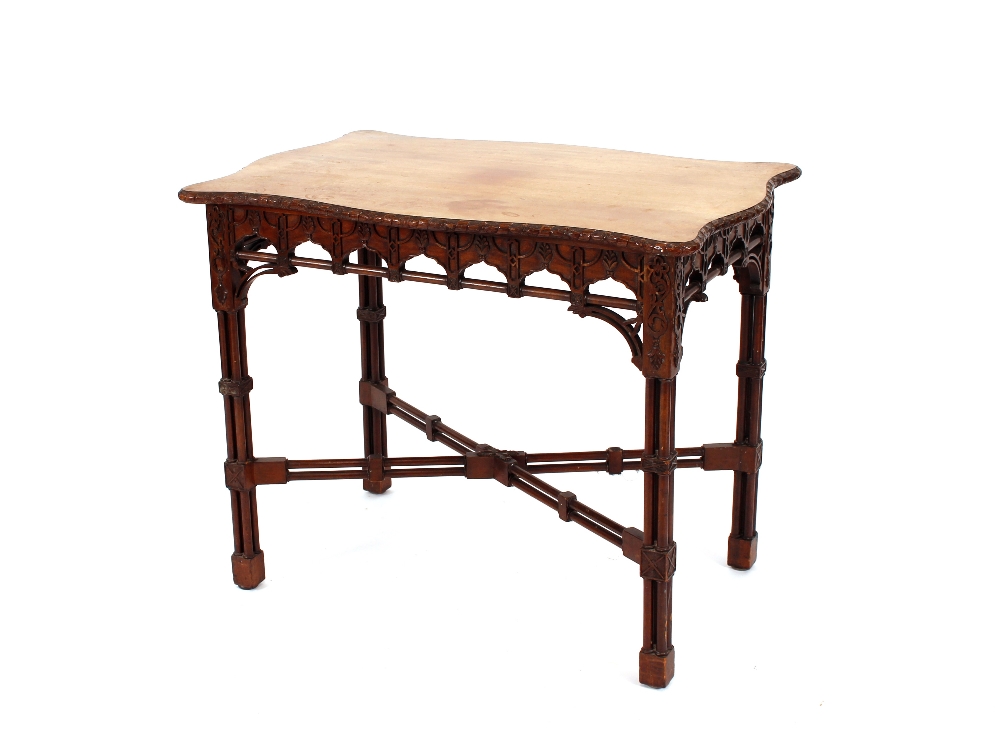 A mahogany Chippendale style side table, the shaped top having carved frieze and raised on cluster