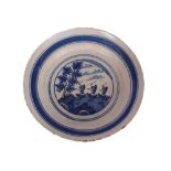 A London Delftware dish, painted in blue with three sailing ships on a stylised sea, rockwork and
