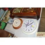 Two wall clocks; an alarm clock and one other