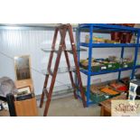 A wooden free standing ladder shelf unit with thre