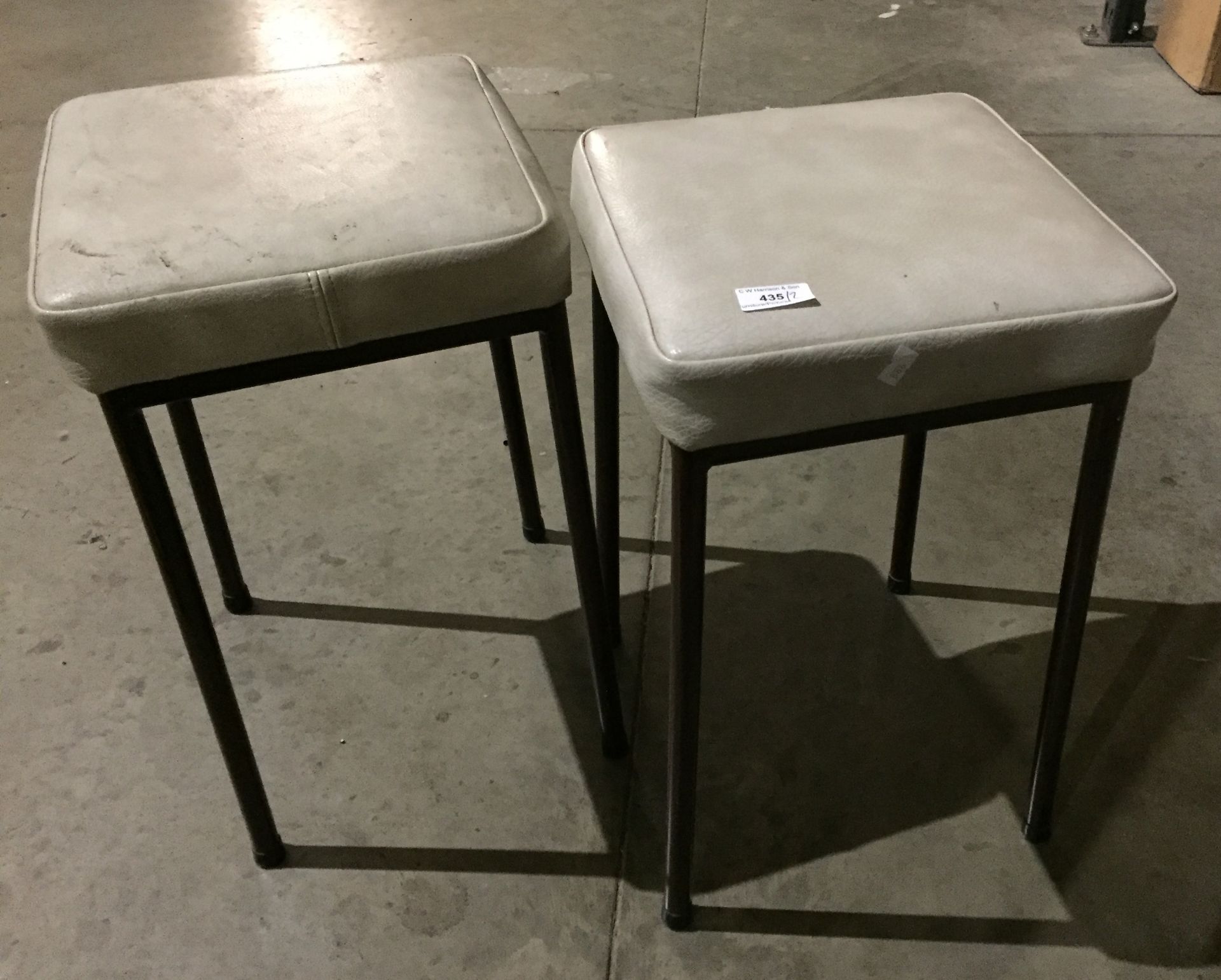 Pair of stools with cream vinyl seats and brown metal legs