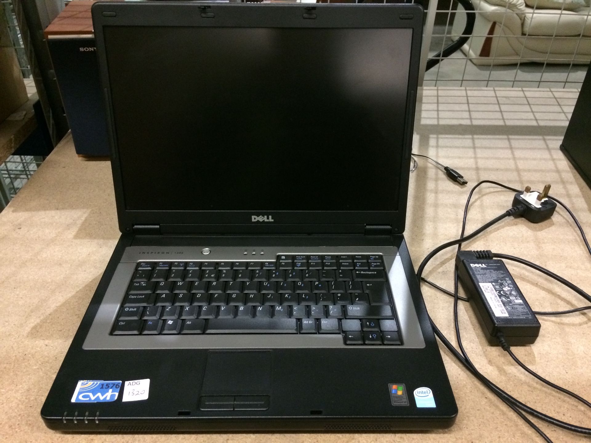 A Dell Inspiron 1300 laptop complete with adapter