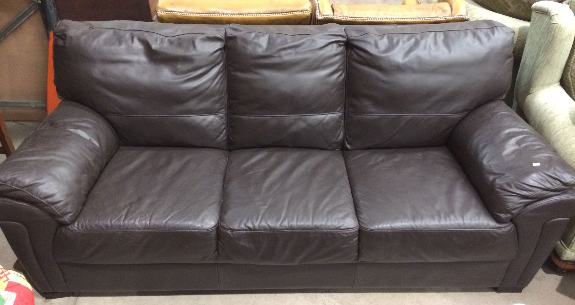 A dark brown leather three seater settee