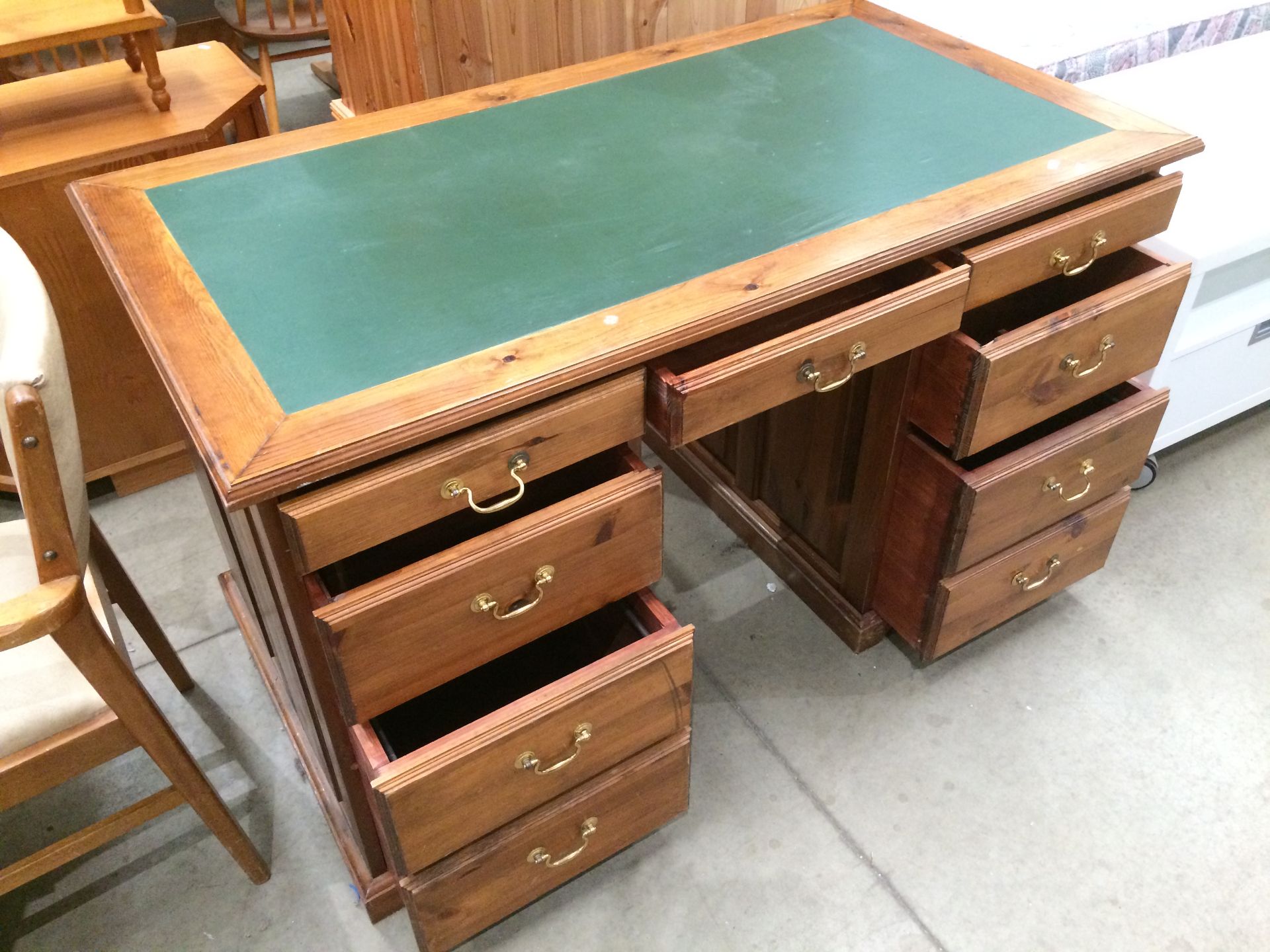 A pine six drawer (two bottom drawers with dummy drawer) twin pedestal desk with green vinyl top,