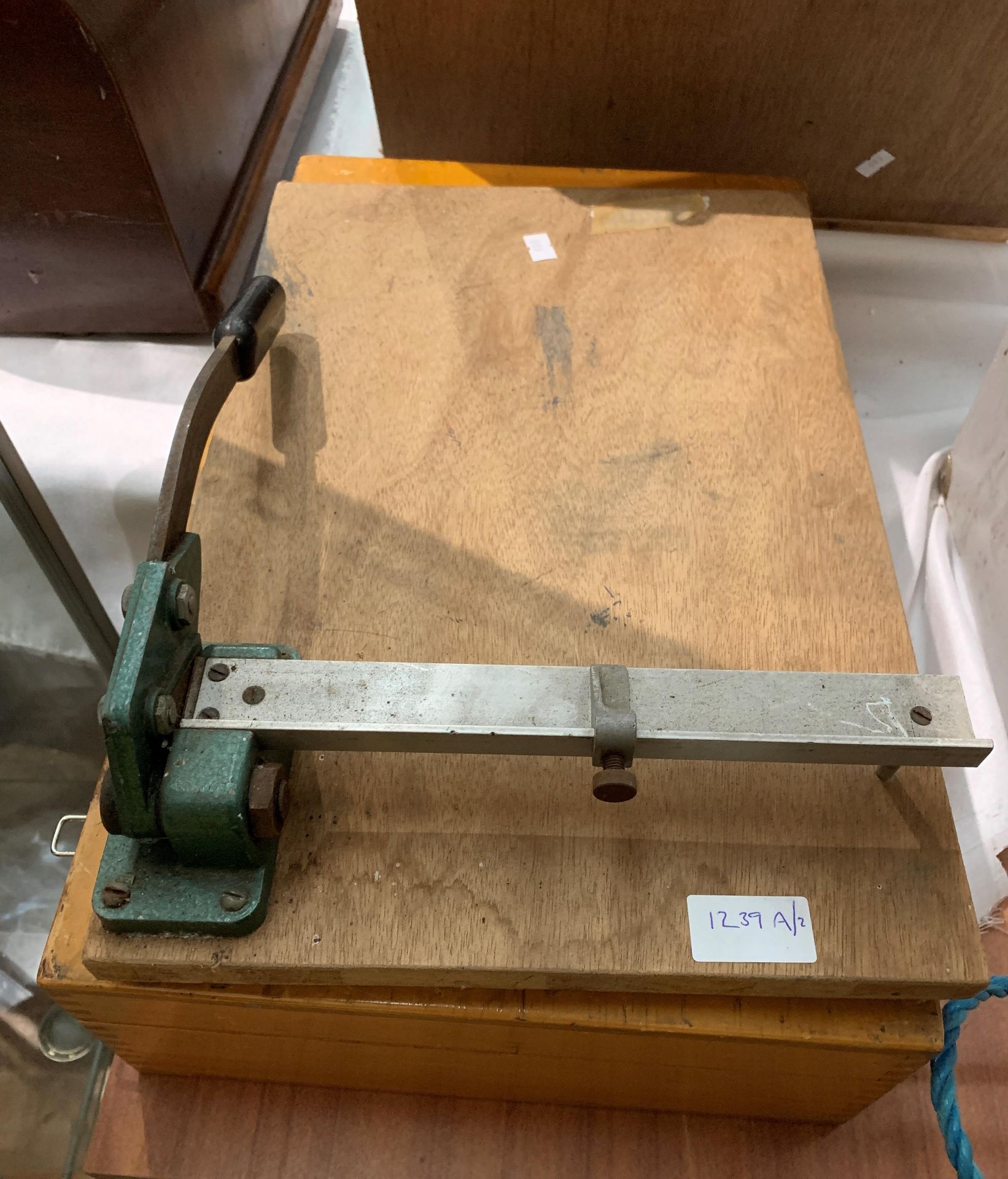 A small manual guillotine and an empty wooden laboratory sample box