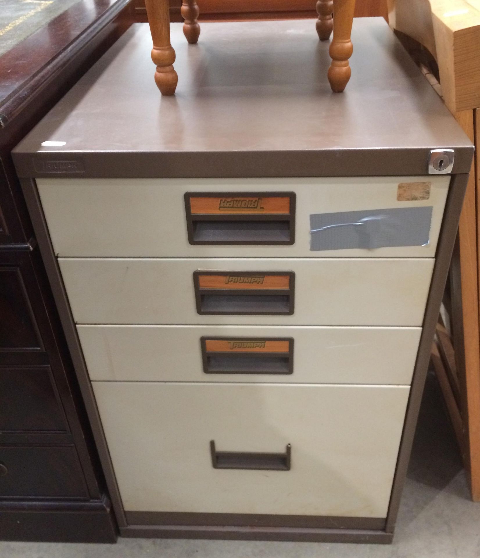 A Triumph brown and beige metal four graduated drawer low filing cabinet