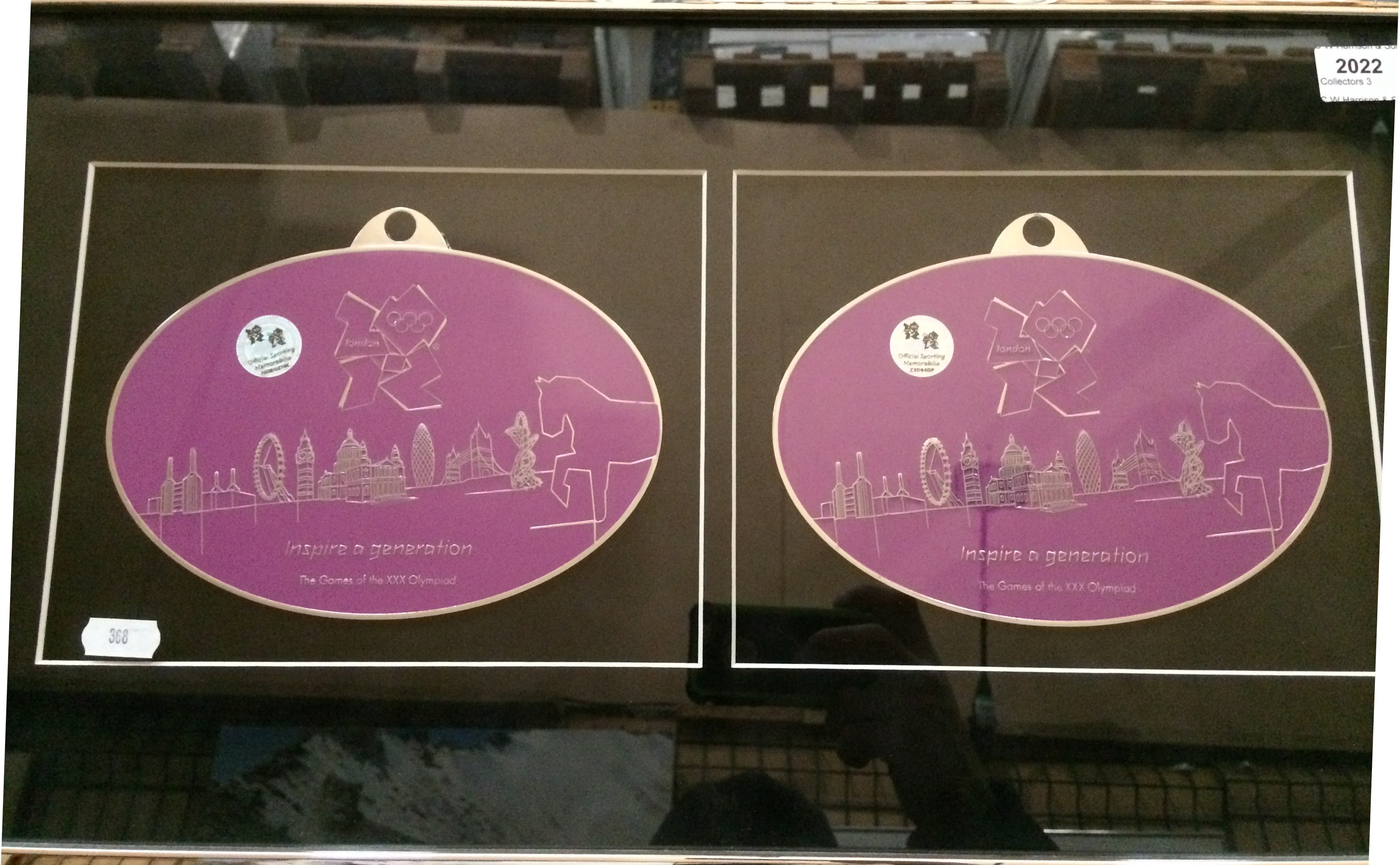 A pair of large oval purple badges inscribed London 2012 - Inspire a Generation,