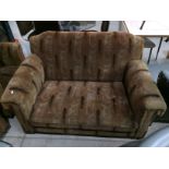 A 1920s brown patterned three piece suite comprising two seater settee and two armchairs